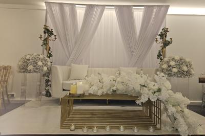 Miniature Location salle Sarcelles (Val-d'Oise) - La Perle #8 Salle décorée pour un événement avec canapés blancs, rideaux, chandeliers dorés et compositions florales blanches.