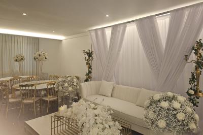 Miniature Location salle Sarcelles (Val-d'Oise) - La Perle #9 Salle décorée pour un événement avec canapés blancs, rideaux, chandeliers dorés et compositions florales blanches.