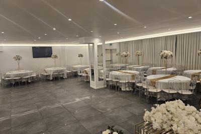 Miniature Location salle Sarcelles (Val-d'Oise) - La Perle #4 Salle décorée pour un événement avec canapés blancs, rideaux, chandeliers dorés et compositions florales blanches.