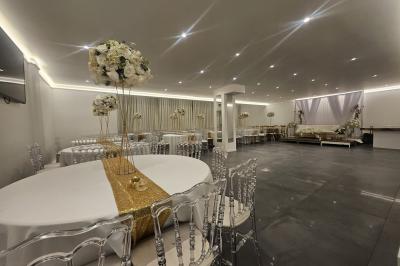 Miniature Location salle Sarcelles (Val-d'Oise) - La Perle #5 Salle décorée pour un événement avec canapés blancs, rideaux, chandeliers dorés et compositions florales blanches.