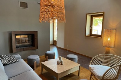 Terrasse en bois avec mobilier de jardin, offrant une vue dégagée sur un paysage verdoyant et boisé.