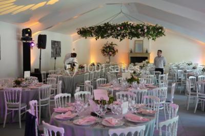 Salle de réunion lumineuse sous combles avec poutres apparentes, tables, chaises et écran de projection installé.