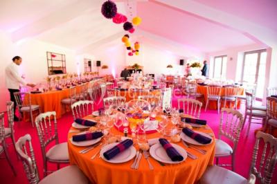 Salle de réunion lumineuse sous combles avec poutres apparentes, tables, chaises et écran de projection installé.