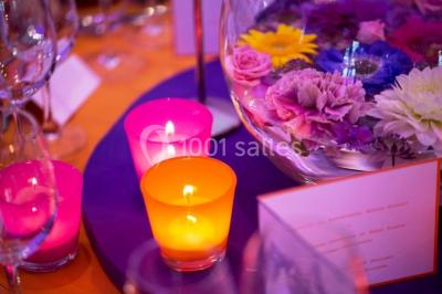 Salle de réunion lumineuse sous combles avec poutres apparentes, tables, chaises et écran de projection installé.