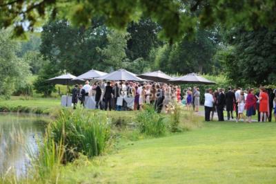 Salle de réunion lumineuse sous combles avec poutres apparentes, tables, chaises et écran de projection installé.