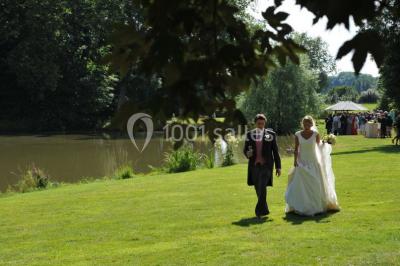 Salle de réunion lumineuse sous combles avec poutres apparentes, tables, chaises et écran de projection installé.