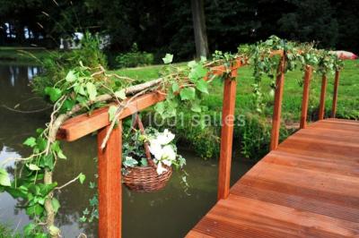 Salle de réunion lumineuse sous combles avec poutres apparentes, tables, chaises et écran de projection installé.