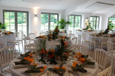 Salle de réunion lumineuse sous combles avec poutres apparentes, tables, chaises et écran de projection installé.