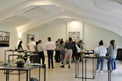 Vue d'un bâtiment en briques avec une tour, entouré d'arbres, d'une pelouse et d'un étang.
