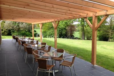 Chemin en pierre menant à une petite maison en bois entourée de végétation dense et ombragée.