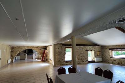 Chemin en pierre menant à une petite maison en bois entourée de végétation dense et ombragée.