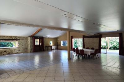 Chemin en pierre menant à une petite maison en bois entourée de végétation dense et ombragée.