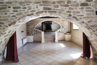 Chemin en pierre menant à une petite maison en bois entourée de végétation dense et ombragée.