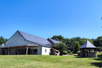 Chemin en pierre menant à une petite maison en bois entourée de végétation dense et ombragée.