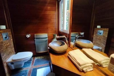 Chemin en pierre menant à une petite maison en bois entourée de végétation dense et ombragée.