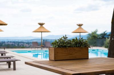 Salle de restaurant moderne avec une grande table en bois, suspensions noires et étagères de bouteilles illuminées.