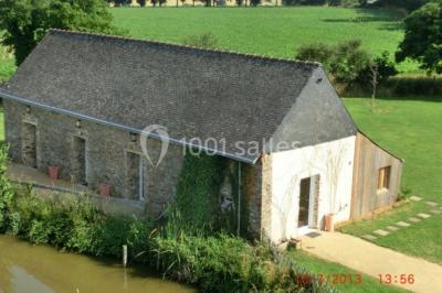 Salle de bain avec lavabo, miroir, toilettes et porte-serviettes, carrelage sombre au sol et murs clairs.