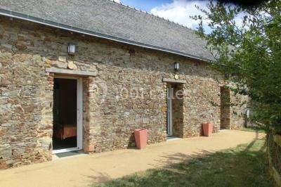 Salle de bain avec lavabo, miroir, toilettes et porte-serviettes, carrelage sombre au sol et murs clairs.