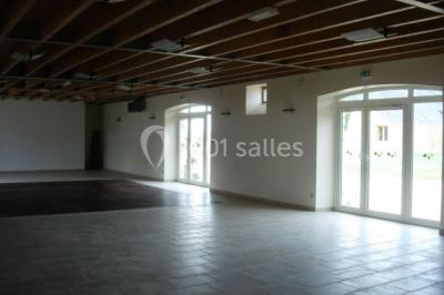 Salle de bain avec lavabo, miroir, toilettes et porte-serviettes, carrelage sombre au sol et murs clairs.