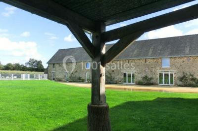 Salle de bain avec lavabo, miroir, toilettes et porte-serviettes, carrelage sombre au sol et murs clairs.
