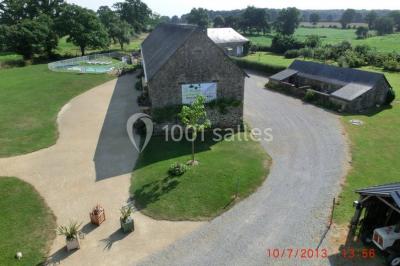 Salle de bain avec lavabo, miroir, toilettes et porte-serviettes, carrelage sombre au sol et murs clairs.