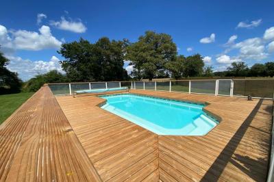 Salle de bain avec lavabo, miroir, toilettes et porte-serviettes, carrelage sombre au sol et murs clairs.