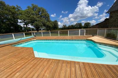Salle de bain avec lavabo, miroir, toilettes et porte-serviettes, carrelage sombre au sol et murs clairs.