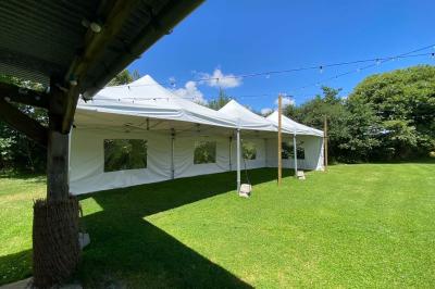 Salle de bain avec lavabo, miroir, toilettes et porte-serviettes, carrelage sombre au sol et murs clairs.