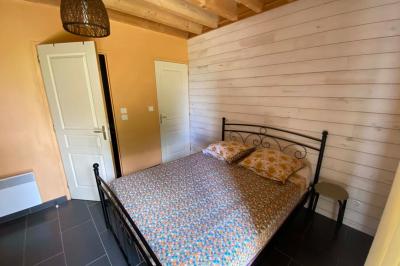 Salle de bain avec lavabo, miroir, toilettes et porte-serviettes, carrelage sombre au sol et murs clairs.