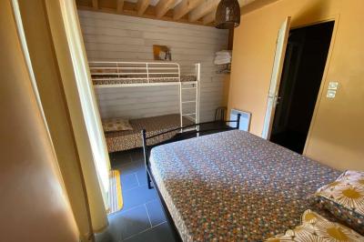 Salle de bain avec lavabo, miroir, toilettes et porte-serviettes, carrelage sombre au sol et murs clairs.