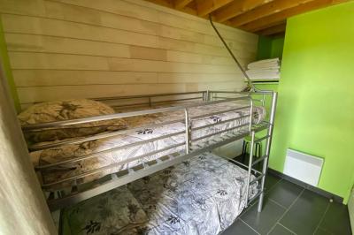 Salle de bain avec lavabo, miroir, toilettes et porte-serviettes, carrelage sombre au sol et murs clairs.