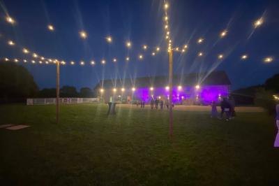 Salle de bain avec lavabo, miroir, toilettes et porte-serviettes, carrelage sombre au sol et murs clairs.