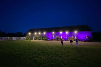Salle de bain avec lavabo, miroir, toilettes et porte-serviettes, carrelage sombre au sol et murs clairs.