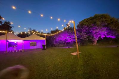 Salle de bain avec lavabo, miroir, toilettes et porte-serviettes, carrelage sombre au sol et murs clairs.