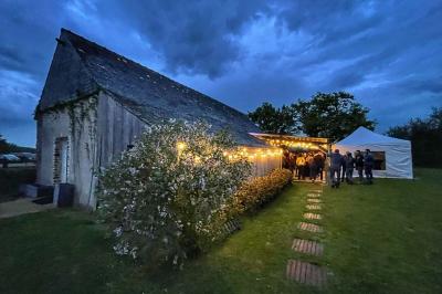 Salle de bain avec lavabo, miroir, toilettes et porte-serviettes, carrelage sombre au sol et murs clairs.