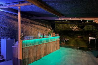 Salle de bain avec lavabo, miroir, toilettes et porte-serviettes, carrelage sombre au sol et murs clairs.