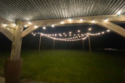 Salle de bain avec lavabo, miroir, toilettes et porte-serviettes, carrelage sombre au sol et murs clairs.