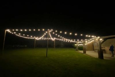Salle de bain avec lavabo, miroir, toilettes et porte-serviettes, carrelage sombre au sol et murs clairs.