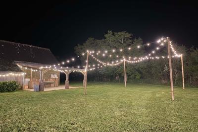 Salle de bain avec lavabo, miroir, toilettes et porte-serviettes, carrelage sombre au sol et murs clairs.