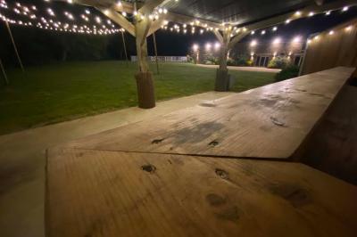 Salle de bain avec lavabo, miroir, toilettes et porte-serviettes, carrelage sombre au sol et murs clairs.