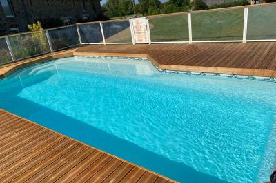 Salle de bain avec lavabo, miroir, toilettes et porte-serviettes, carrelage sombre au sol et murs clairs.