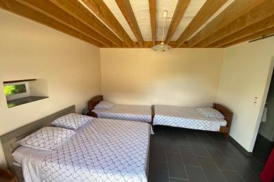 Salle de bain avec lavabo, miroir, toilettes et porte-serviettes, carrelage sombre au sol et murs clairs.