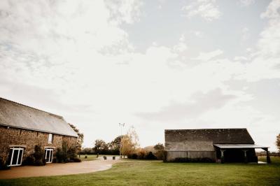 Salle de bain avec lavabo, miroir, toilettes et porte-serviettes, carrelage sombre au sol et murs clairs.