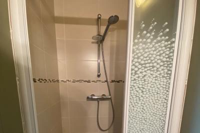 Salle de bain avec lavabo, miroir, toilettes et porte-serviettes, carrelage sombre au sol et murs clairs.