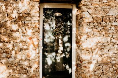 Salle de bain avec lavabo, miroir, toilettes et porte-serviettes, carrelage sombre au sol et murs clairs.