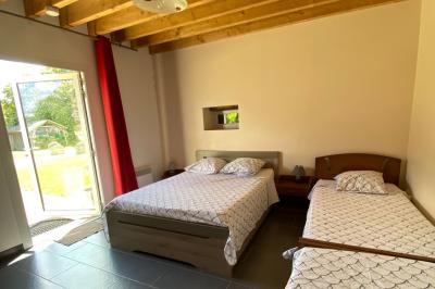 Salle de bain avec lavabo, miroir, toilettes et porte-serviettes, carrelage sombre au sol et murs clairs.