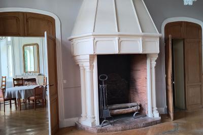 Dortoir avec lits superposés en métal noir, murs rouges et blancs, sol en carrelage foncé, éclairage au plafond.