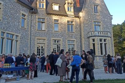 Dortoir avec lits superposés en métal noir, murs rouges et blancs, sol en carrelage foncé, éclairage au plafond.