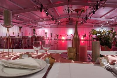 Dortoir avec lits superposés en métal noir, murs rouges et blancs, sol en carrelage foncé, éclairage au plafond.