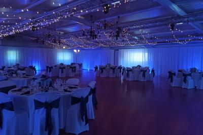 Dortoir avec lits superposés en métal noir, murs rouges et blancs, sol en carrelage foncé, éclairage au plafond.